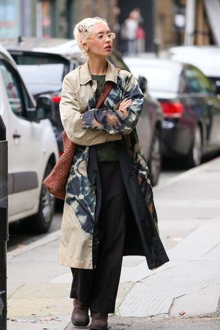 Iris Law carrying the Dune XL bag and wearing a trench coat in London