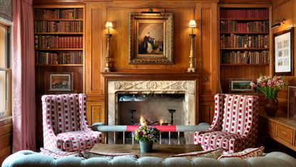 Library with wood panneling and fire place