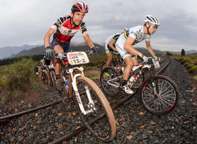 Max Knox (L) and Nino Schurter (R) negotiate a railroad crossing during Cape Epic stage 1