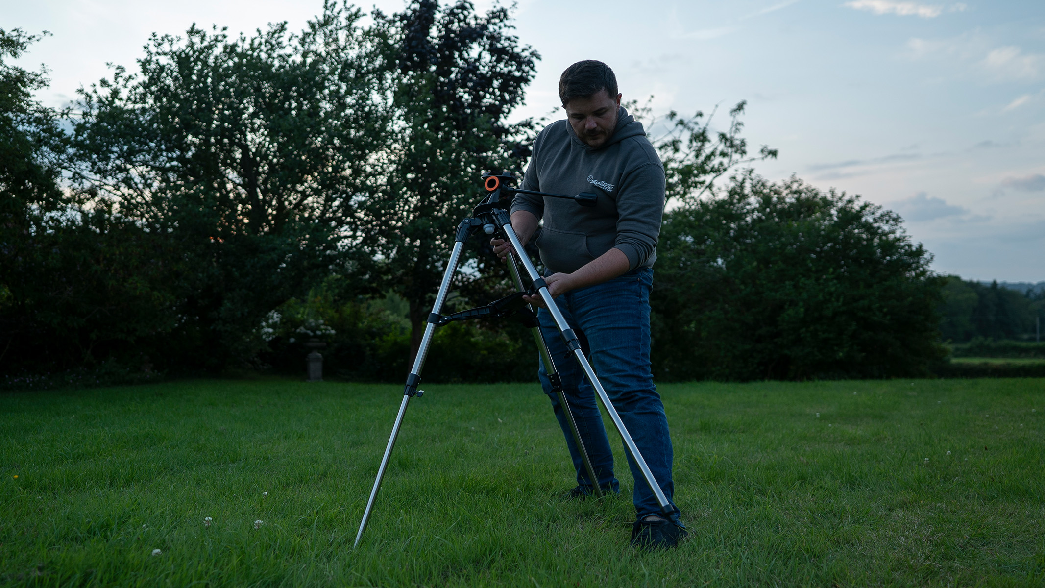 Man setting up a telescope in a field