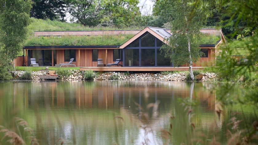 single storey timber frame house with timber cladding, green roof and pitched gable end