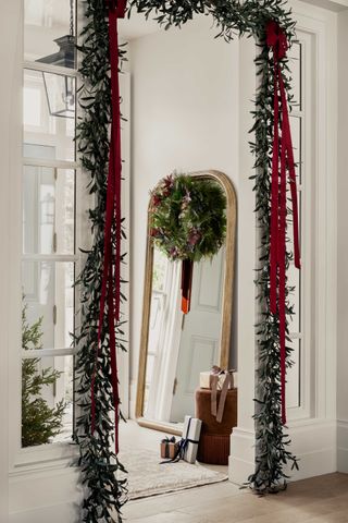 a doorway decorated with christmas foliage