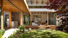 An outdoor garden with a pair of woven chairs on the lawn