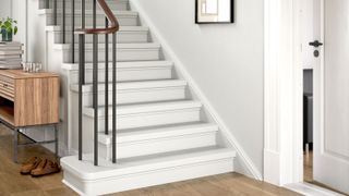 Contemporary hallway with wooden floor, black stair spindles, wooden handrail and painted white stairs