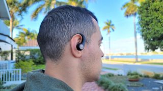 Our reviewer testing the Tribit MoveBuds H1's comfort and fit