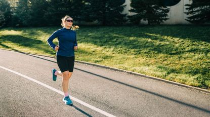Woman running after gait analysis wearing running shoes along sunny road