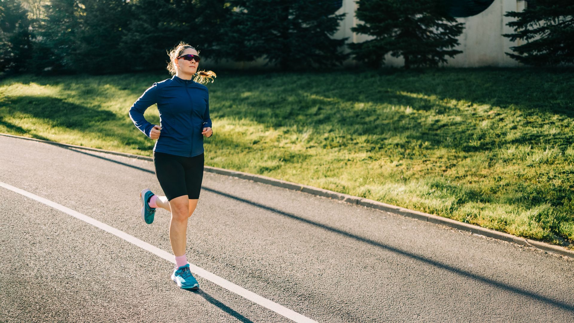 Woman running after gait analysis wearing running shoes along sunny road