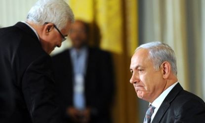 Israeli Prime Minister Benjamin Netanyahu shakes hands with Palestinian President Mahmoud Abbas.