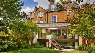 large modern rear extension with ground and lower floor levels extending outwards from large brick detached property