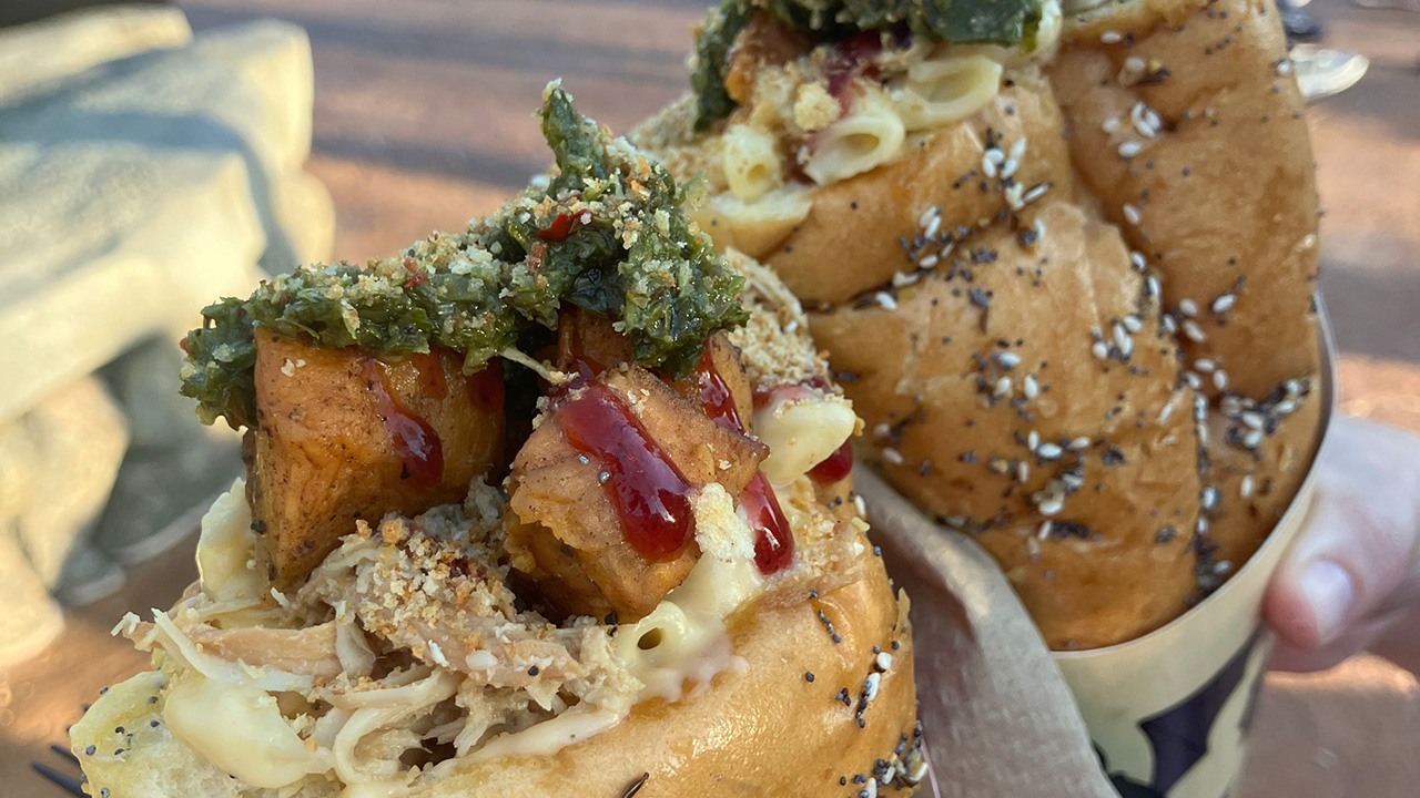 The new holiday Mac n cheese cone at Universal Orlando with sweet potatoes, lingonberry jam and chimichurri on top, two cones pictured.