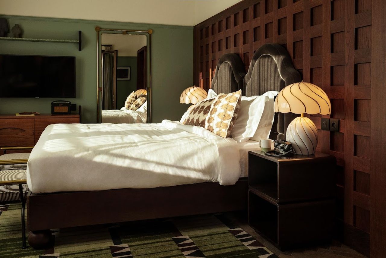 An imaginatively decorated Roman hotel features a green and brown colo scheme, whimsical furniture, and lots of leather accents.