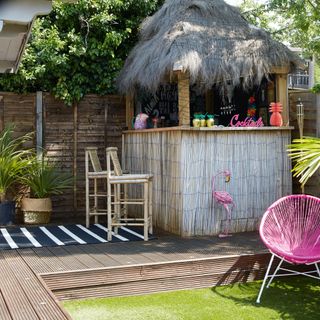 decking area with wooden hut and grass lawn