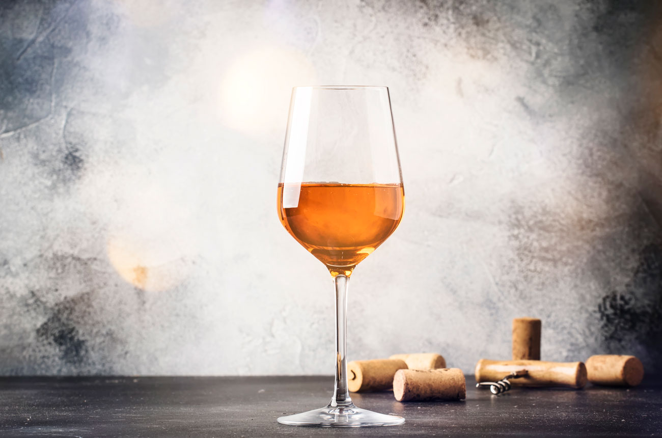 A glass of orange wine with corks