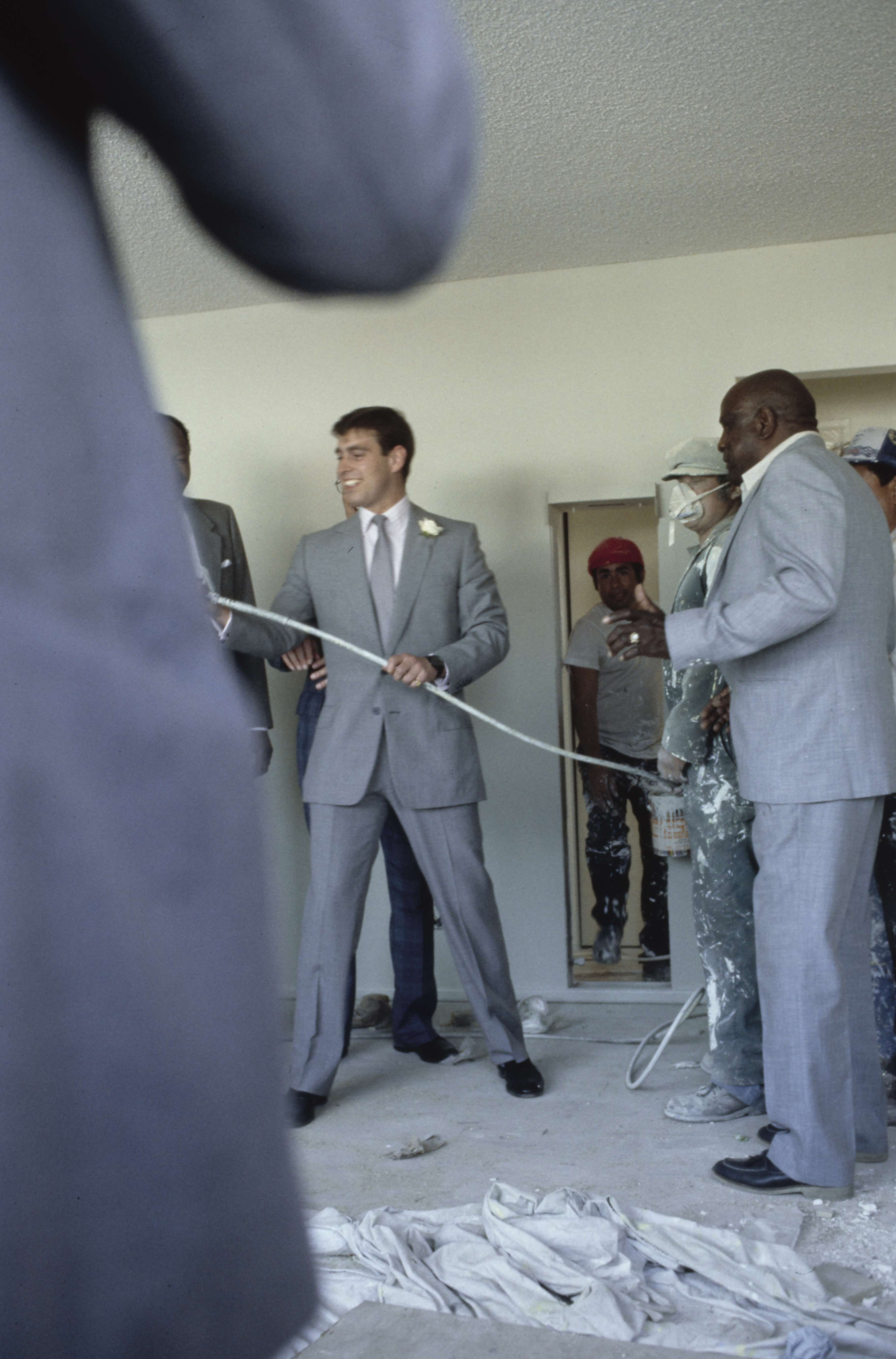 Prince Andrew wearing a gray suit holding a paint spray gun