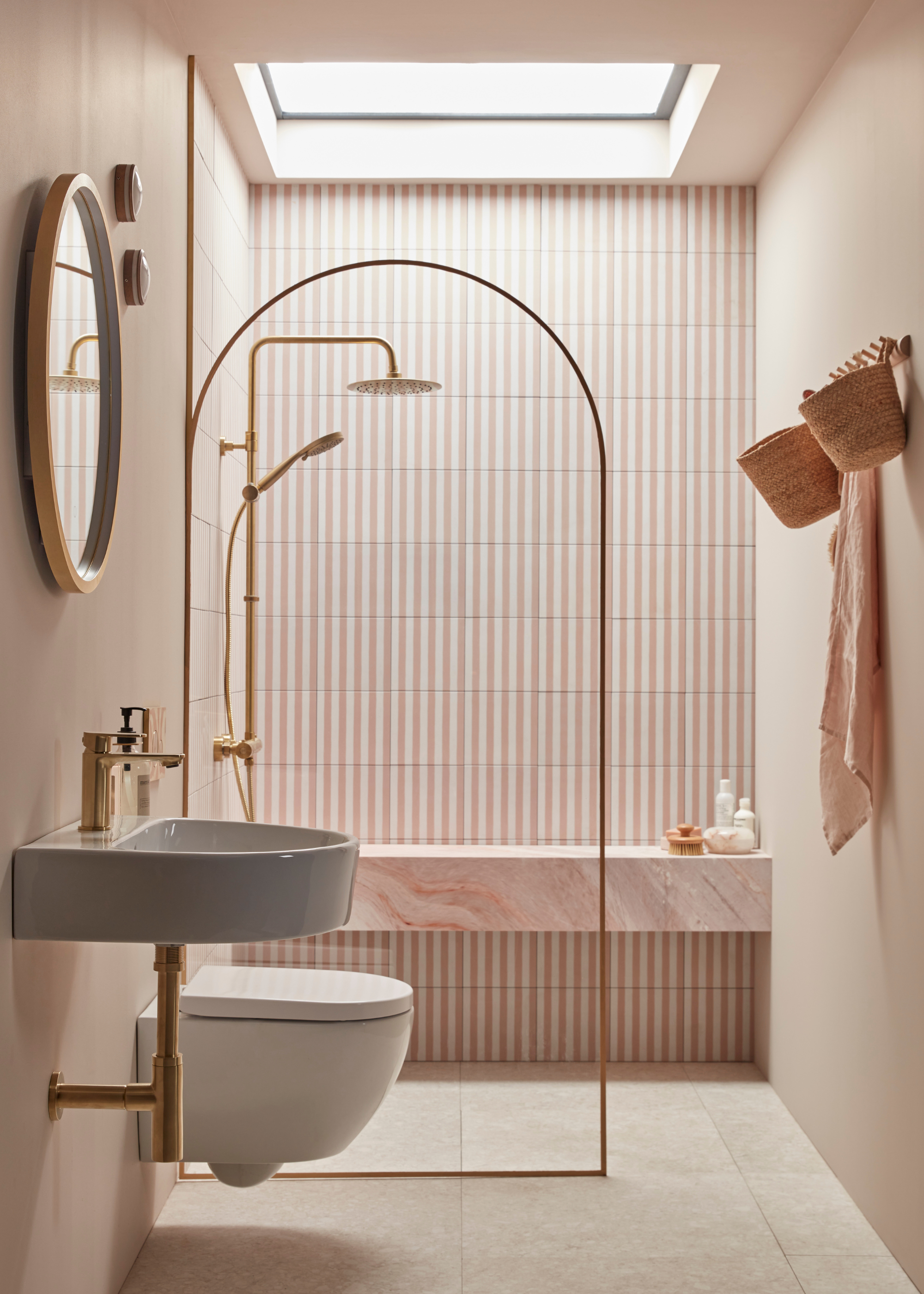 a pink and white striped tiled shower room with a pink stone shower seat