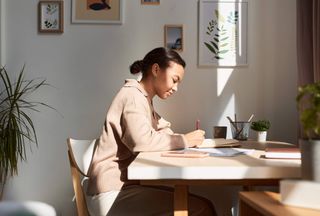 A woman sat at a desk using a notebook.