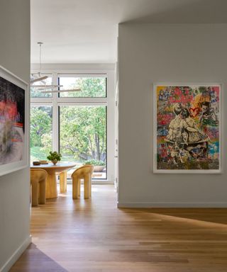 view to eat-in kitchen from hall with white walls and bold artwork