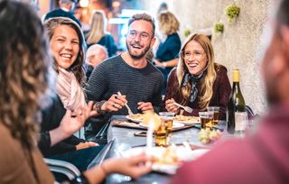 group of friends eating a substantial meal together in tier 2 restrictions