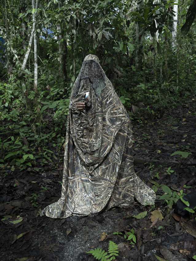 A person dressed in camoflauge in a forest