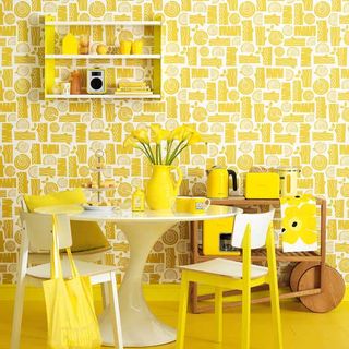 room with printed yellow wall and flower in vase