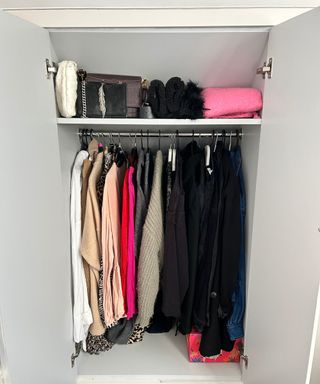 Neatly organised minimalist style wardrobe with black clothes on the right