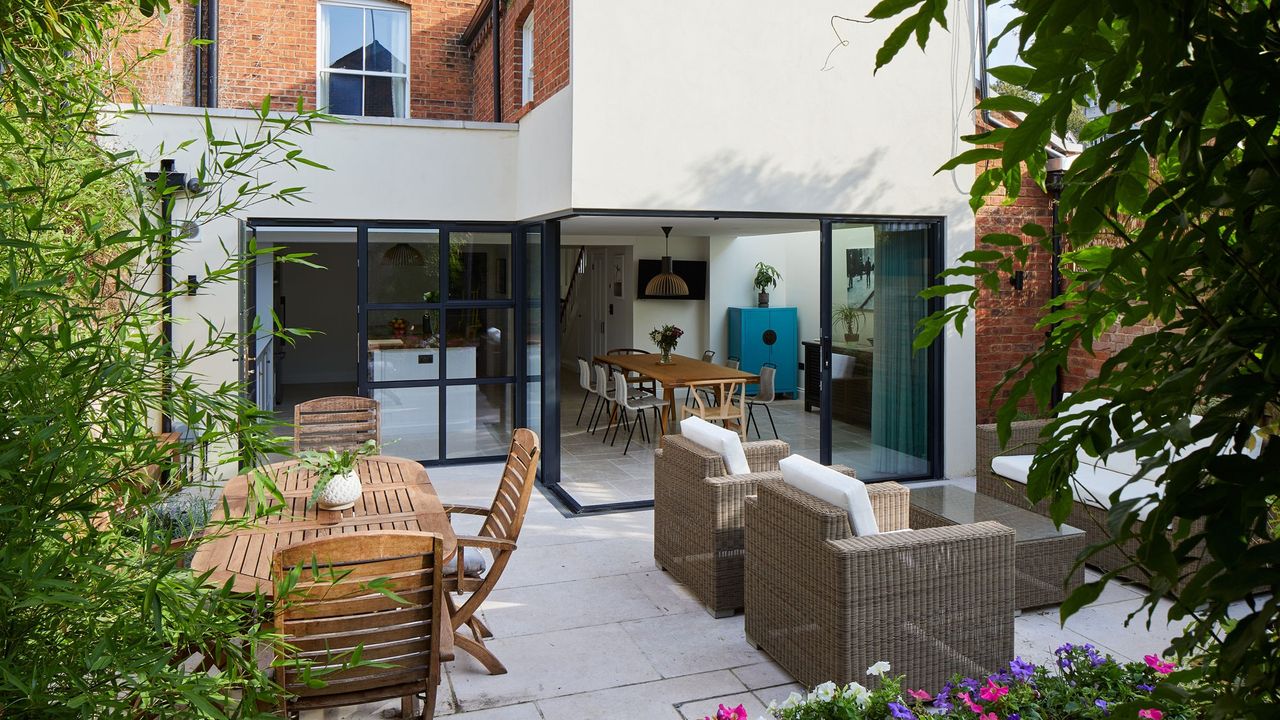 house exterior with red brick and white wall dinning table with chairs and sofa set