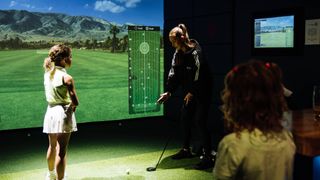 Annabel Dimmock gives a junior girl golfer a lesson