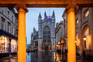 Bath Abbey lit up through pillars