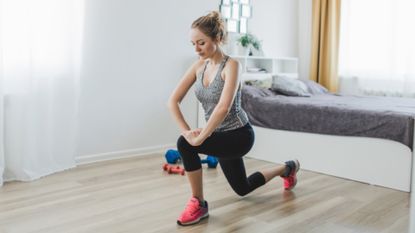 Woman doing bodyweight lunges in her bedroom
