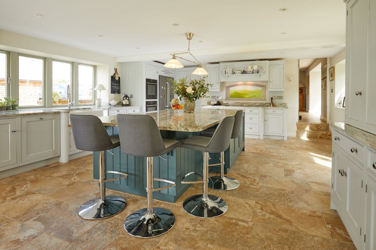 Kitchen-diner with wooden flooring and a kitchen island sitting in the middle of the room