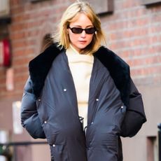 Jennifer Lawrence styled a scarf over pants, a butter yellow rollneck sweater, and socks with ballet flats in NYC