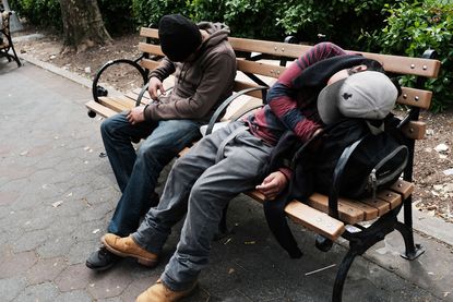 Men sit passed out in a park where heroin users gather to shoot up in the Bronx.