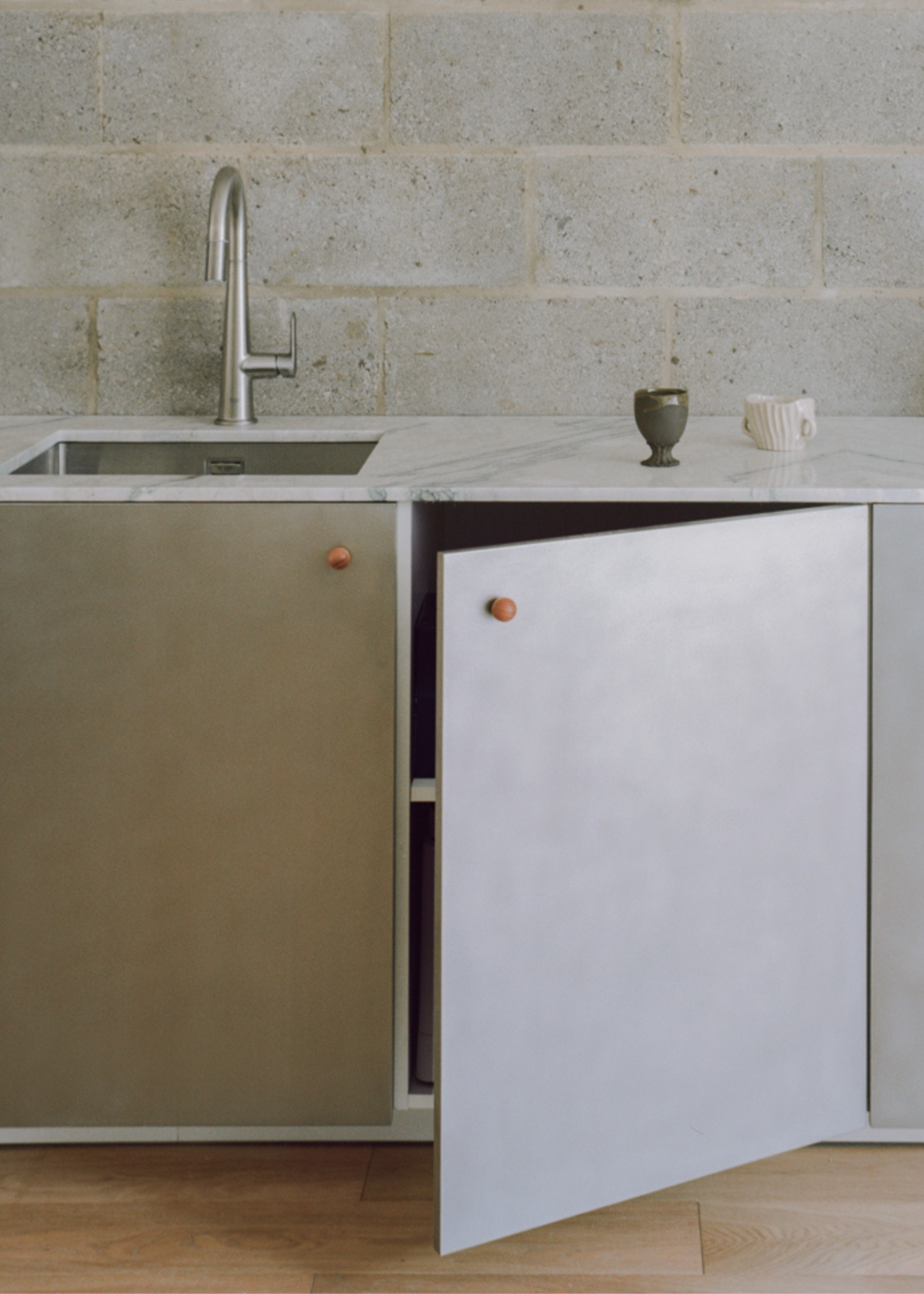 a brushed stainless steel kitchen against a breezeblock wall
