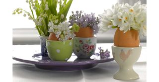 Egg cups used as creative Easter table decorations with flowers