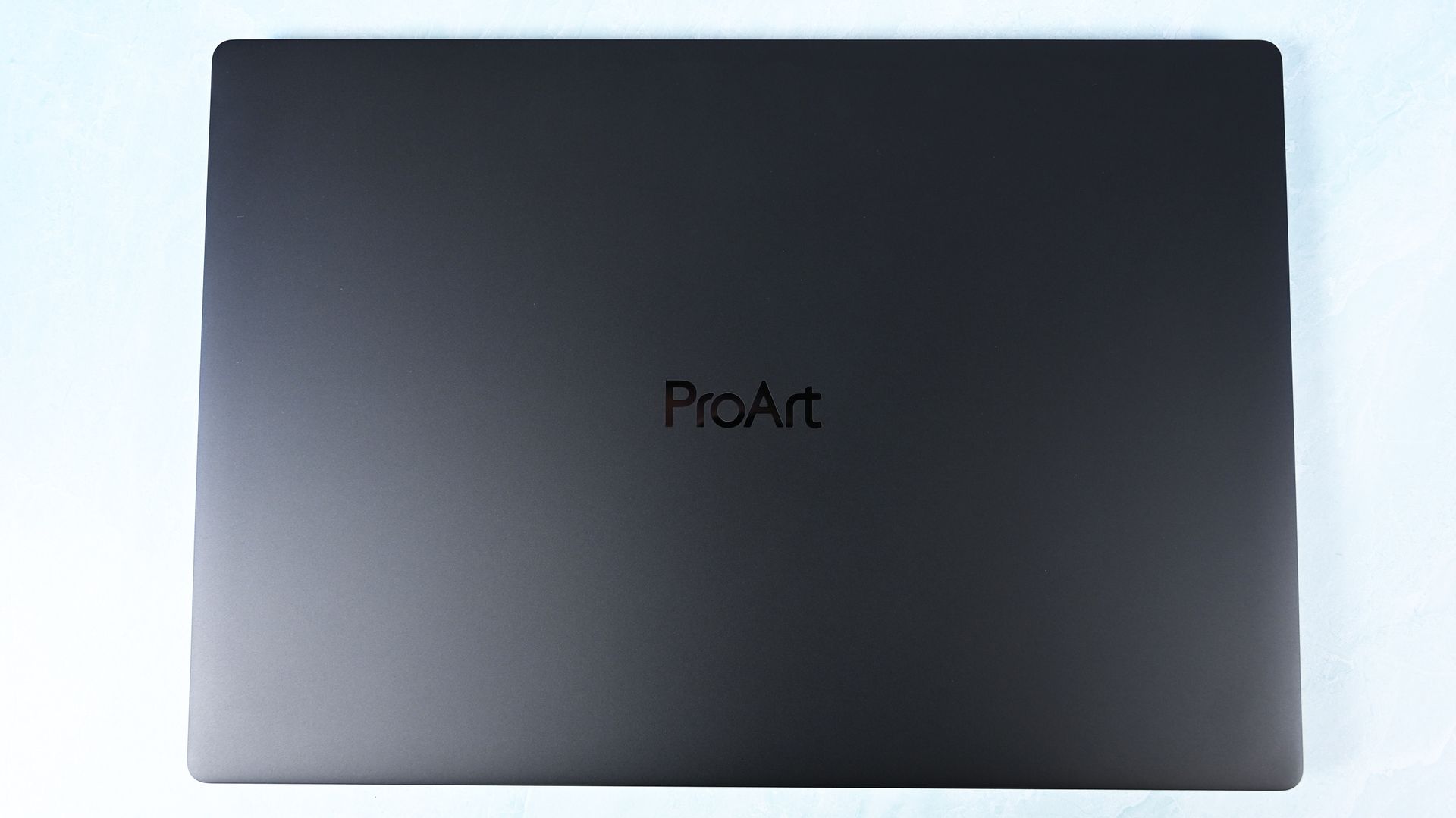 Top-down view of the closed ASUS ProArt P16 laptop featuring a minimalist matte black lid with a subtle centered ProArt logo.
