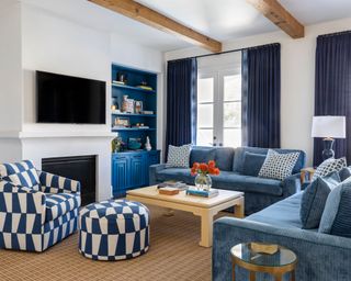 Blue, white and brown living room, seating area gathered around TV above fireplace