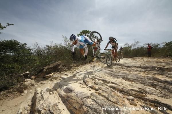 A racer does an endo on a rocky section