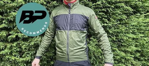 Man wearing Castelli Unlimited Puffy gravel Jacket in front of hedge
