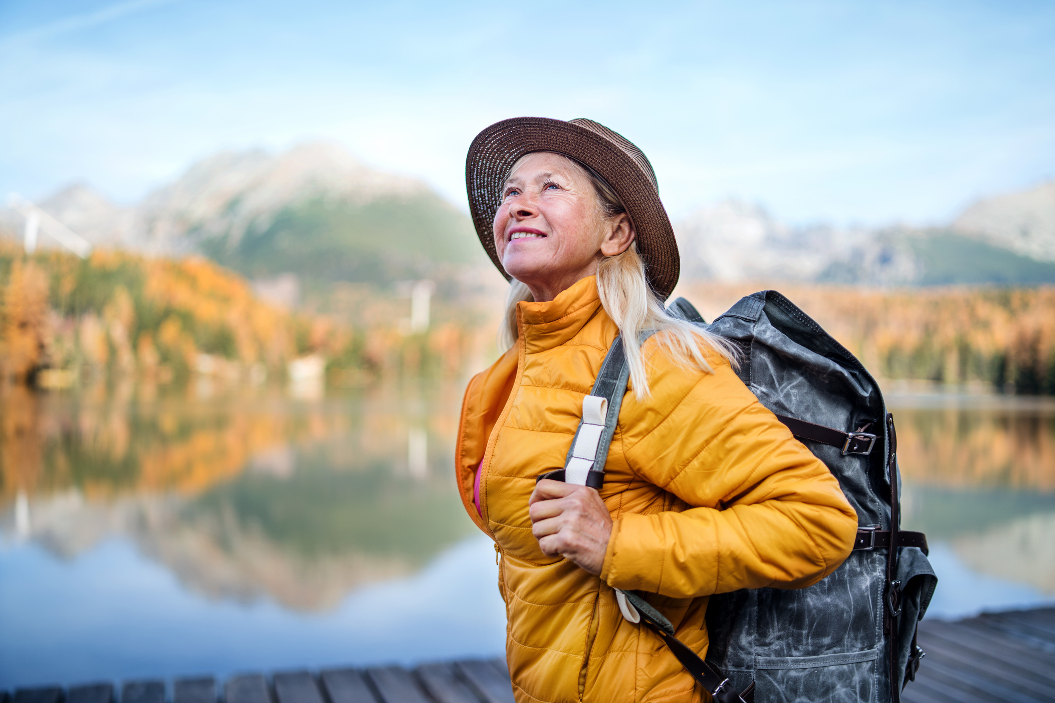 Side view of senior woman hiking in autumn nature,
