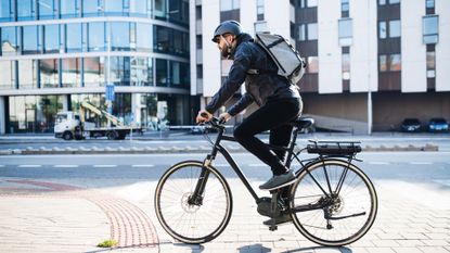 Image shows cyclist wearing one of the best commuter backpacks for cycling