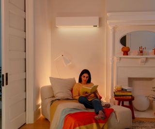 woman sitting in living room with air conditioning unit