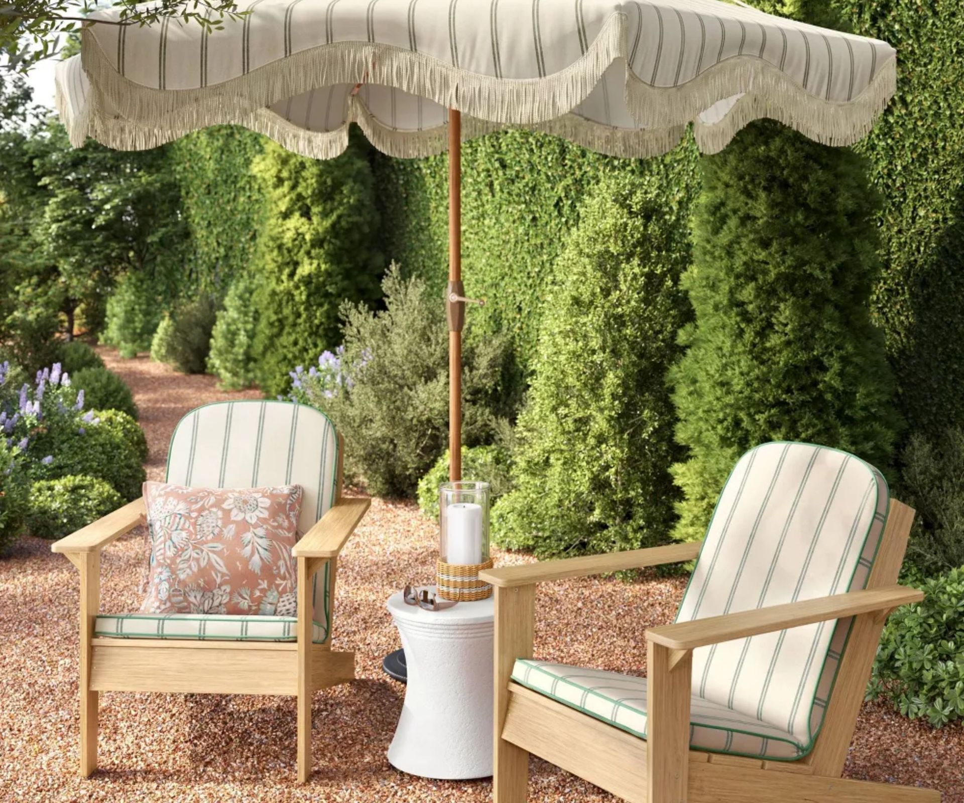 outdoor patio wooden seating with a striped fringed umbrella and matching outdoor furniture cushions
