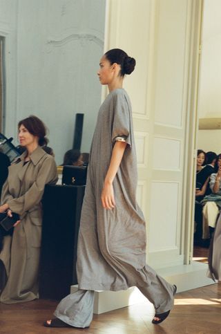 The Row model wearing a gray dress with matching pants on the SS24 runway.