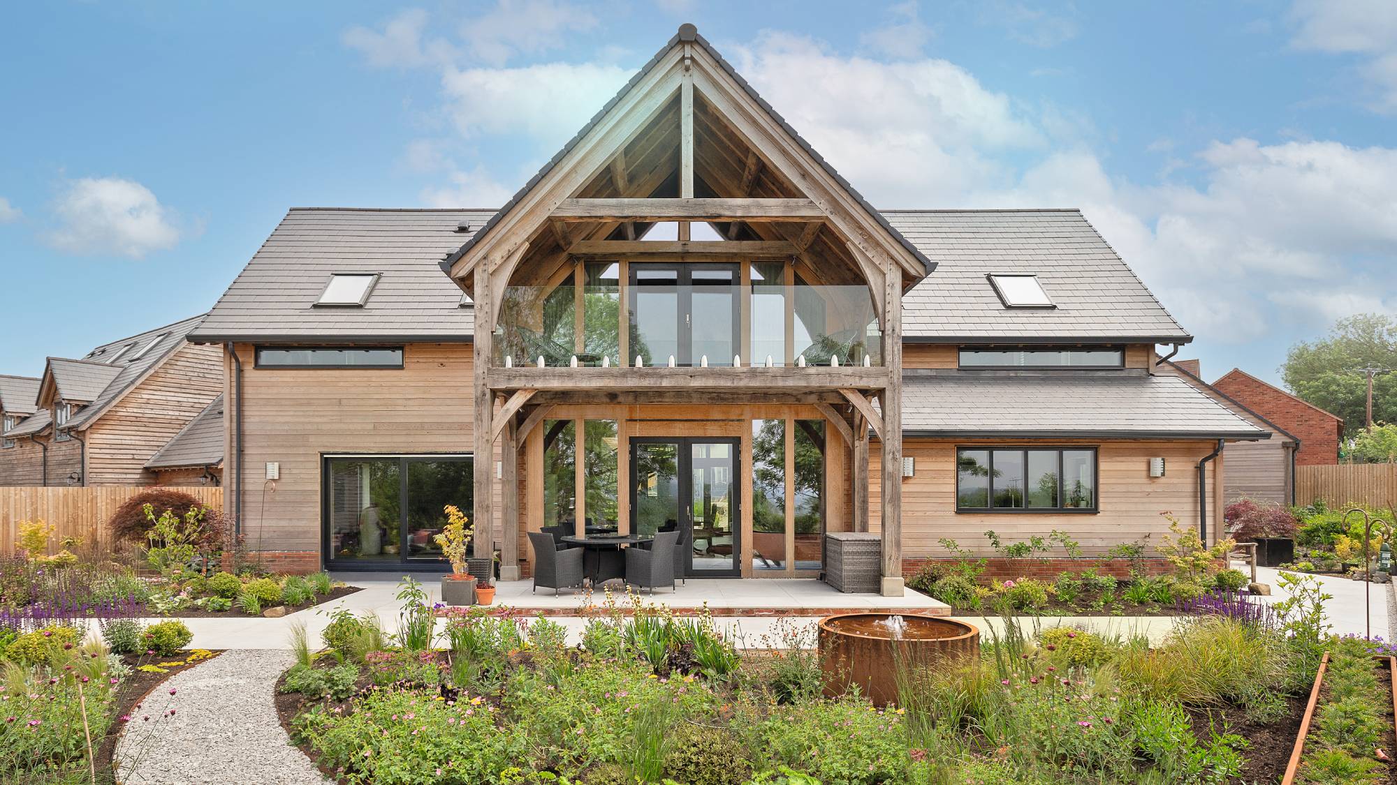 Exterior of oak frame detached house with garden and pathway in front 