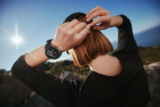 A woman wearing the OnePlus Watch 2 with the sunlight shining brightly.