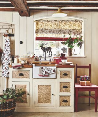Kitchen Christmas decor ideas with festive prints on the blinds, cupboards and tea towels