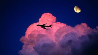 The outline of a Boeing aircraft with clouds and moon in the background