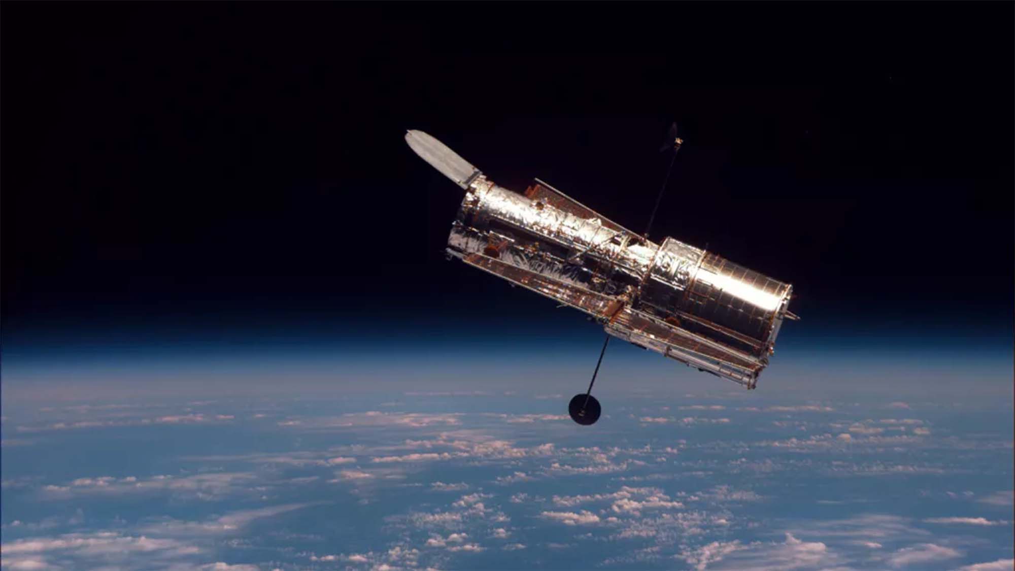 The Hubble Space Telescope as seen from the space shuttle Discovery during the second servicing mission in 1997