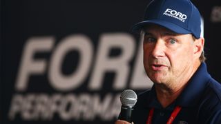 Ford CEO Jim Farley holding a microphone.