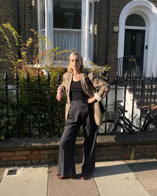 Woman wearing a blazer and high-waisted pleated pants in London.